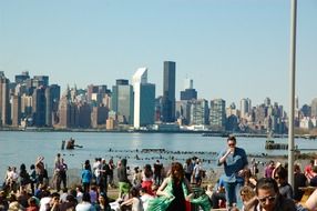 people resting against new york city skyline, usa