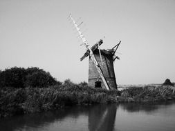 Old hystorical windmill on river bank, england