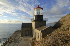 point sur lighthouse on rock at ocean, usa, california