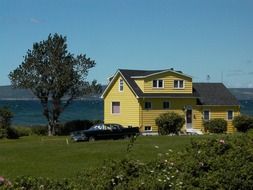 black car beside suburban house on lawn at water, canada