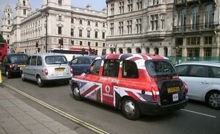 union flag painted taxi cab on road in city, uk,england, london