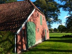 red brick farm building with tile roof at summer