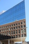 brown building reflected in the glass facade