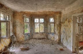 lapsed interior of house with broken windows