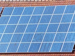 blue solar cells on red tile roof