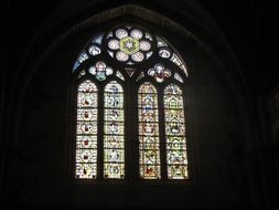 colorful stained glass lattice window in church in a dark