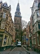 church with clock on bell tower in old alley, netherlands, amsterdam