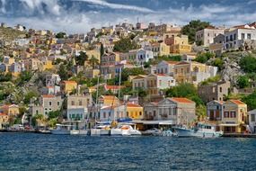 boats in harbour at colorful coastal city, greece, symi