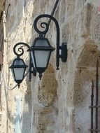 two vintage street lanterns on stone wall