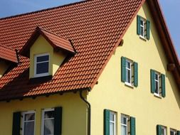 house with yellow facade and red tile roof