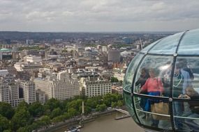 people in cabin of ferris wheel above city, uk, england, london