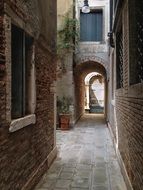 narrow walk path at old brick facades, italy, venice