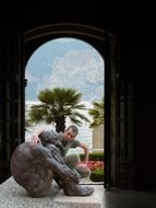young man embracing sculpture in arch