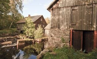 old farm buildings at stream in sweden