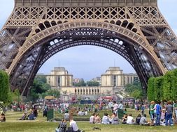 people resting on lawn at eiffel tower at summer, france, paris