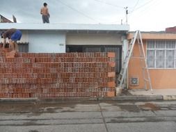 men working with red brick at building