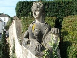 sphinx with shield, aged sculpture on wall of garden, germany, saarbrucken