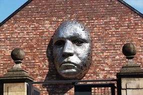 face, sculpture on brick wall, uk, england, lincoln, drill hall