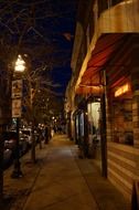 shops on sidewalk in city at night, usa, maryland, baltimore, hampden