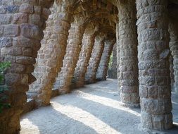 passage with columns by gaudí, spain, barcelona, guell park