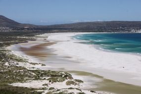 distant town at mountains on ocean coastline, south africa, scarborough