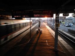 train passing platform of nishi-gifu railway station at sunset, japan, gifu