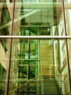 Ladder with handrail on a background of green glass