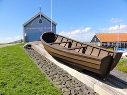 wooden boat on hill at blue building, netherlands