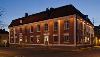 illuminated two-storey corner building at night, sweden