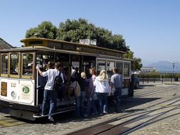 people climbing vintage cable car, usa, california, san francisco