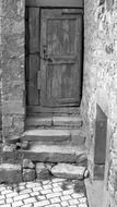 closed old wooden door at stone steps