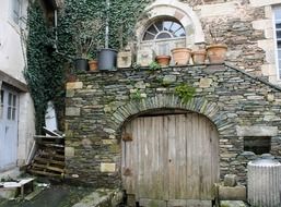 picturesque old stone wall with wooden door in backyard