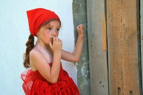 caucasian child girl in red clothing at wall