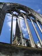 spire of cathedral behind gothic ruin, france, normandy, rouen