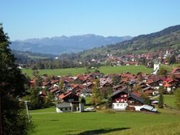 picturesque village in valley at green mountains, germany, allgÃ¤u, bad oberdorf