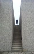 woman silhouette at sky atop of stone stairs in wall