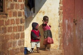 dark skin children at grunge brick house, uganda