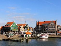 tourist boat at pier in front of colorful buildings, netherlands