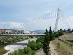 suspension bridge across foamy river, montenegro, podgorica