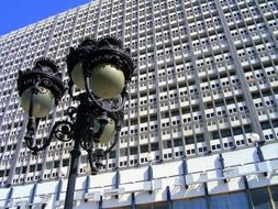 wrough iron vintage street lanterns at facade of modern office building