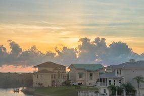 scenic clouds in sunset sky above modern villas on coast, usa, florida