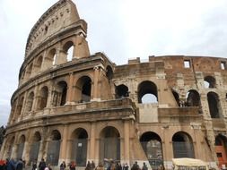 people at grated arches of colosseum, italy, rome