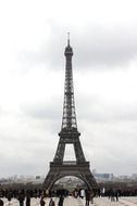 crowd of people at eiffel tower in cloudy evening, france, paris