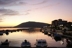 boats at pier in coastal town at dusk, greece, lefkas, lefkada