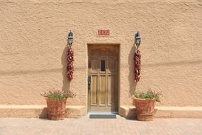 bunches of dry pepper on vintage lanterns at entrance door