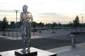 standing person, modern transparent metal sculpture in park