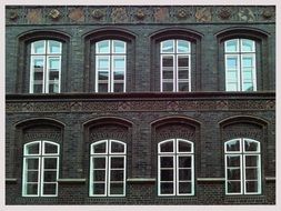 two rows of lattice window on old ornamented facade