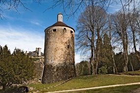 aged tower in park at fall, france