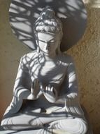 shadows on grey stone buddha statue