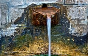 ancient fountain on stone wall close up, greece, lesbos